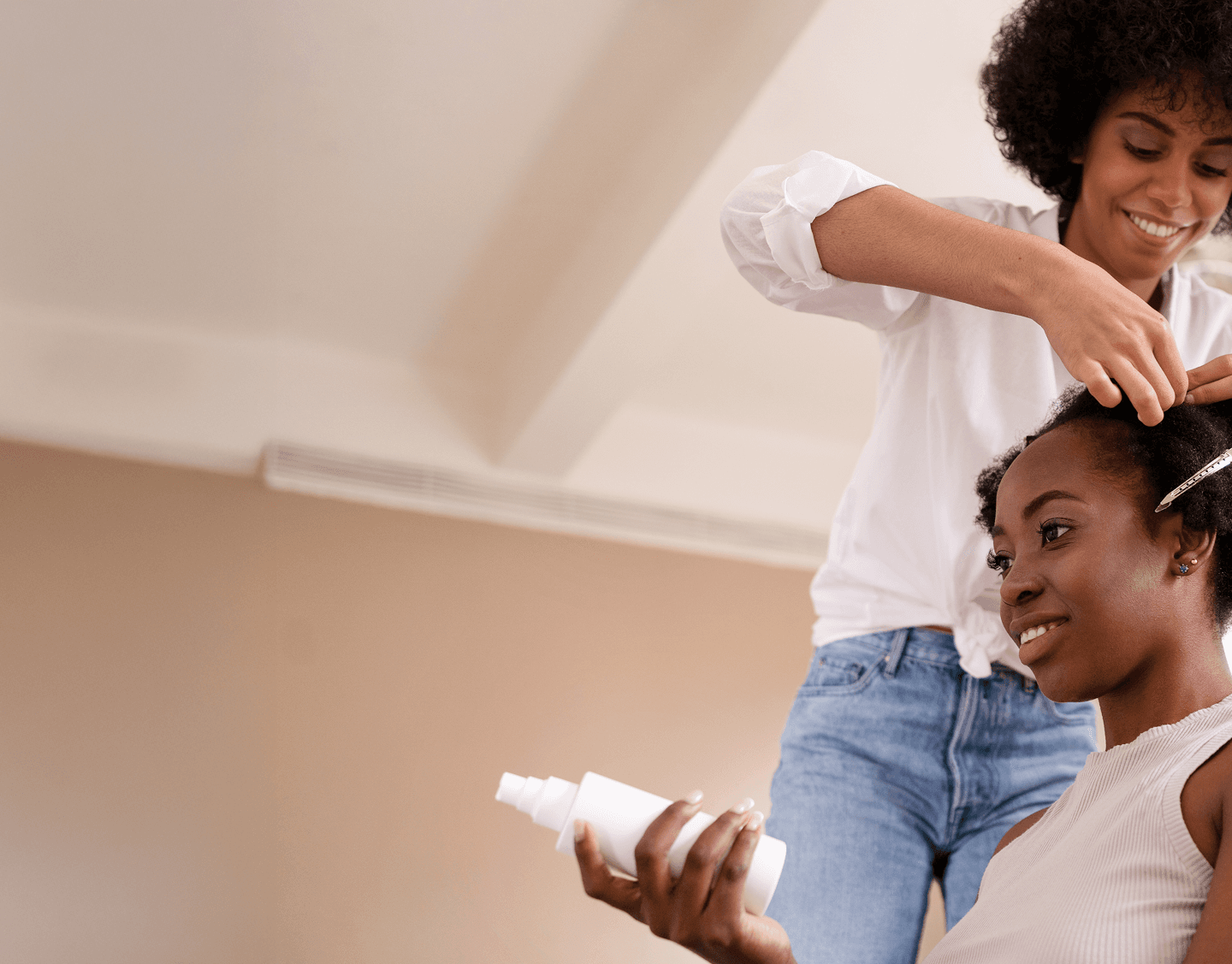 A close-up of a beautician painting a woman's nails.
